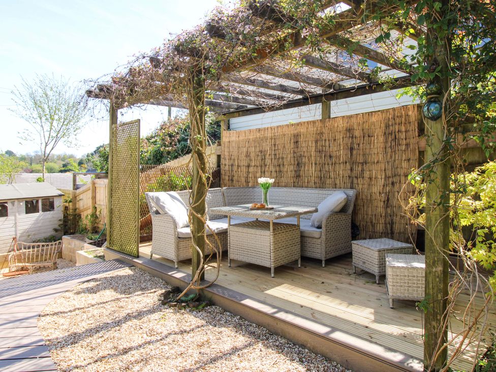 A garden with outdoor seating and a table at Park Cottage in Kingston, Kingsbridge