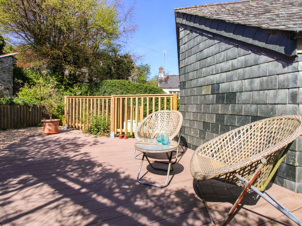 An outdoor patio with chairs and a table at Park Cottage Kingston, Kingsbridge