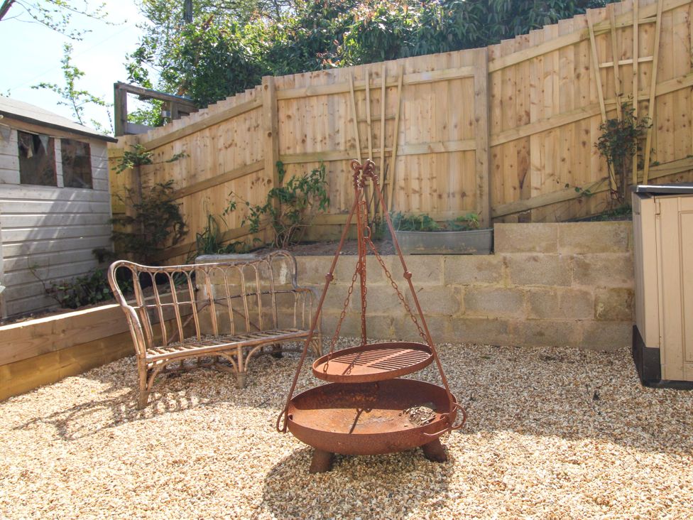 A garden with a fire pit and a bench at Park Cottage in Kingston, Kingsbridge