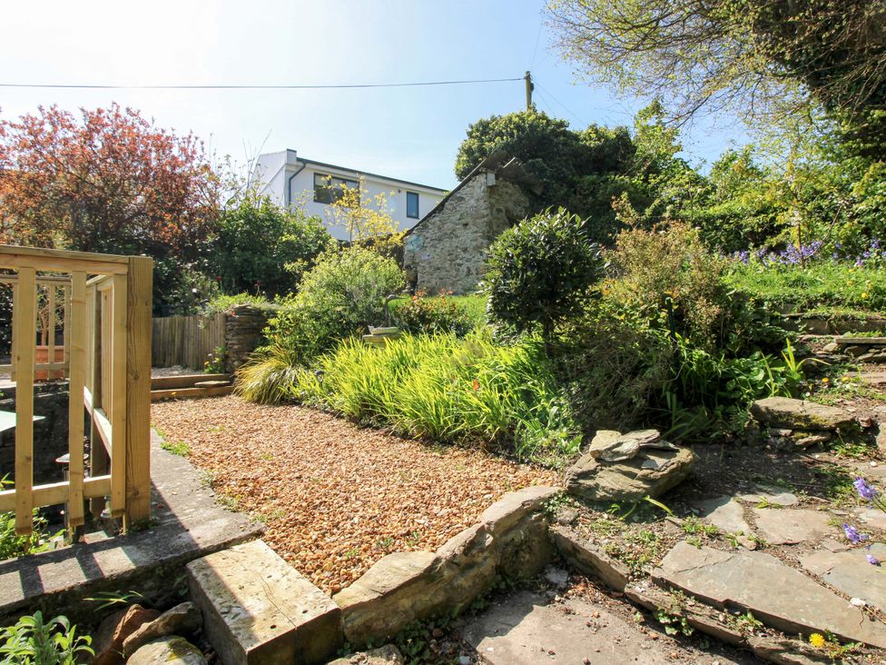 A garden with stone steps and plants at Park Cottage in Kingston, Kingsbridge