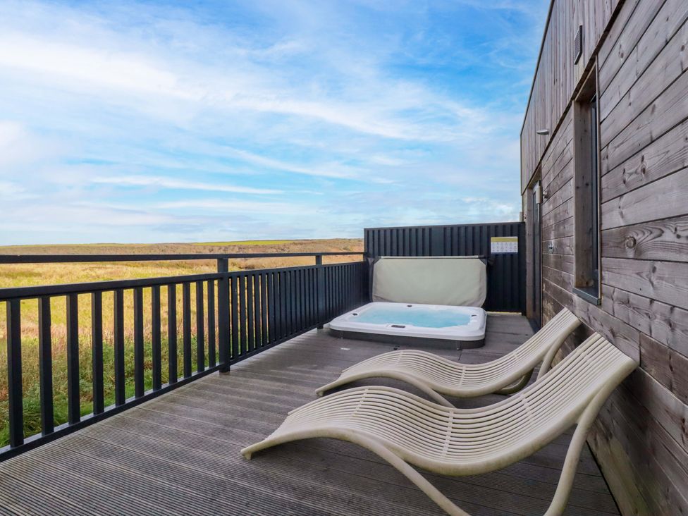 An outdoor area with a hot tub and deck chairs at 114 - The Residance Redruth