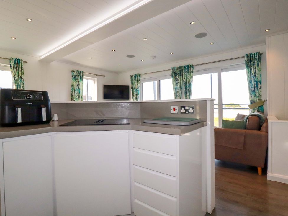 A kitchen with an air fryer and television at 114 - The Residance Redruth