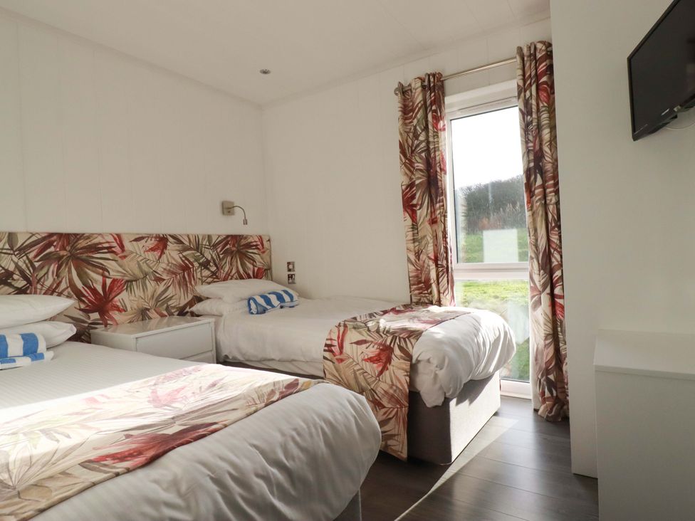 A bedroom with two beds and a television at 114 - The Residance Redruth