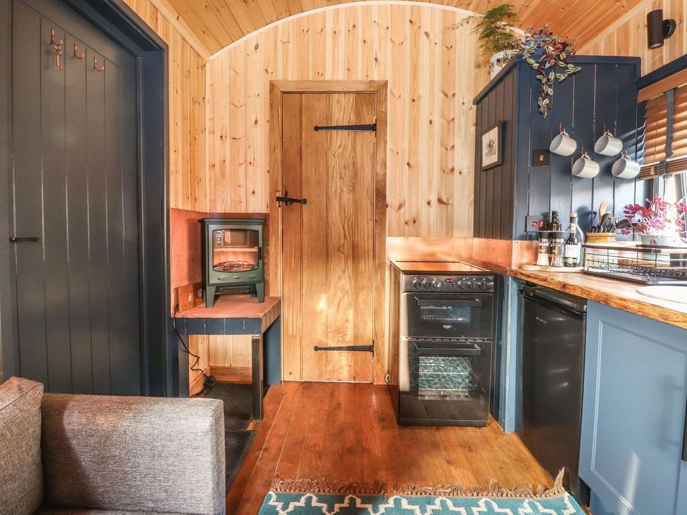 A kitchen with a stove and refrigerator at Dunfell Shepherd's Hut Appleby-In-Westmorland