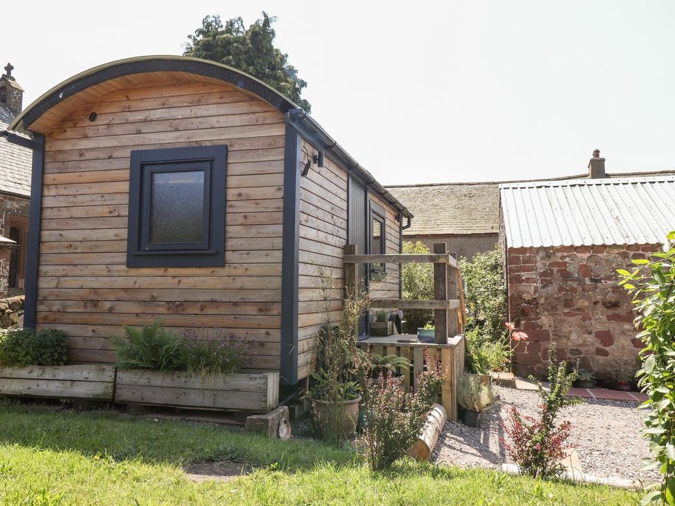 A wooden hut with plants in the garden at Dunfell Shepherd's Hut Appleby-In-Westmorland
