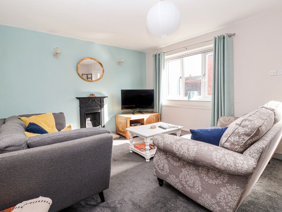 A living room with a sofa and television at Mallard Cottage Nafferton