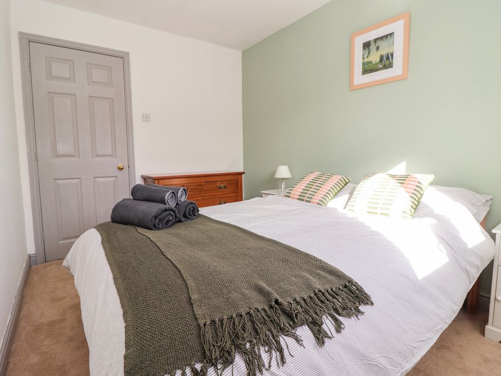 A bedroom with a bed and towels on top at Mallard Cottage Nafferton