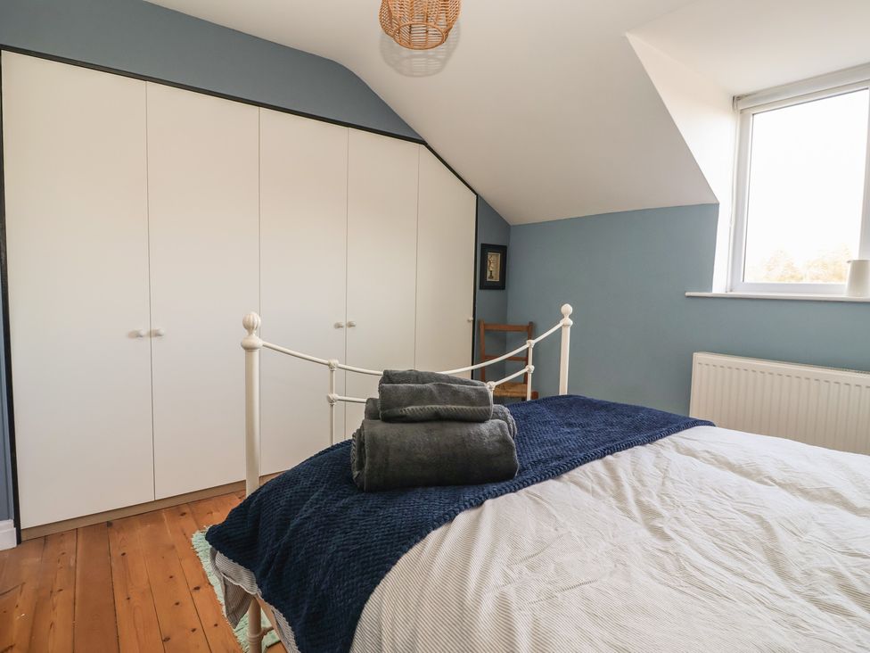 A bedroom with a bed and wardrobe at Mallard Cottage in Nafferton