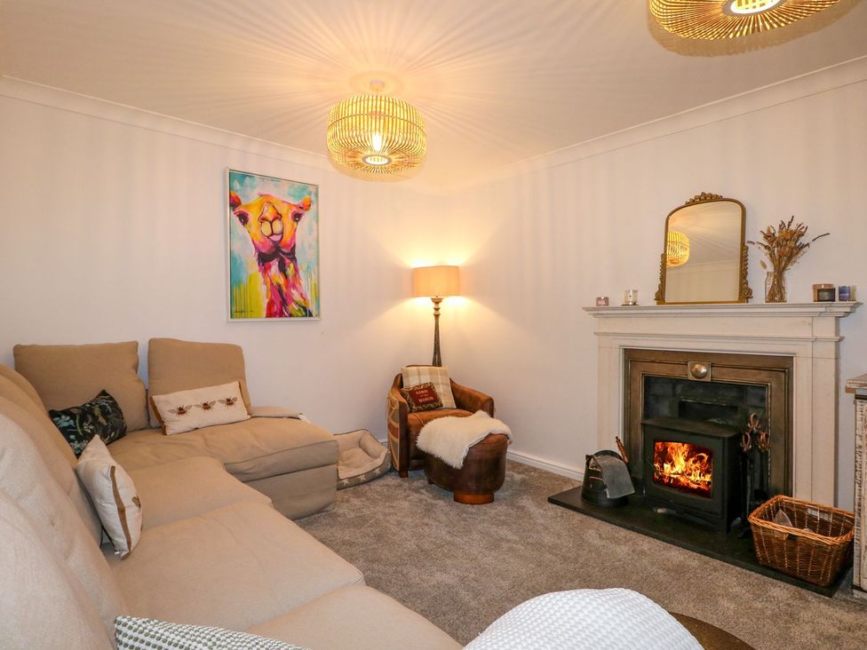 A living room with a sofa, lamp, fireplace, and painting at Number 5