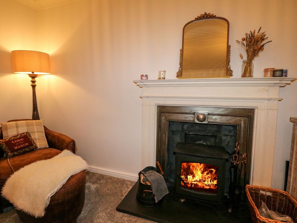 A living room with a fireplace and armchair at Number 5