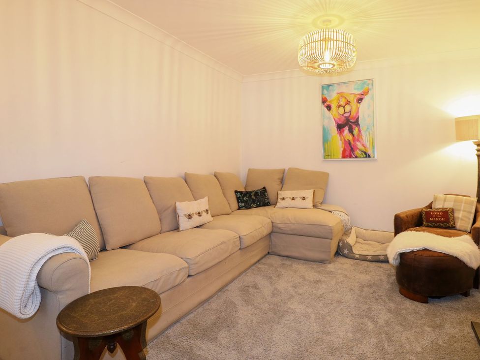 A living room with a sectional sofa and wall art at Number 5