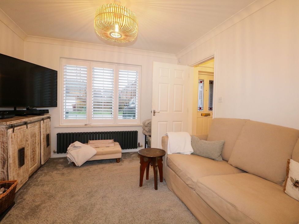 A living room with a TV, coffee table, and sofa at Number 5