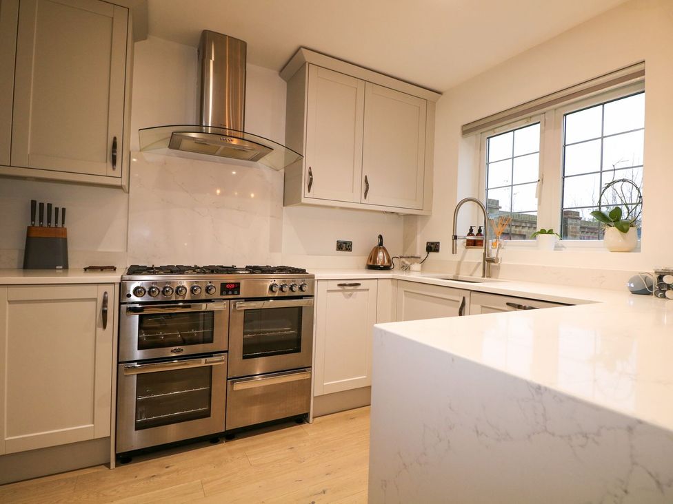 A kitchen with an oven, stove, and sink at Number 5