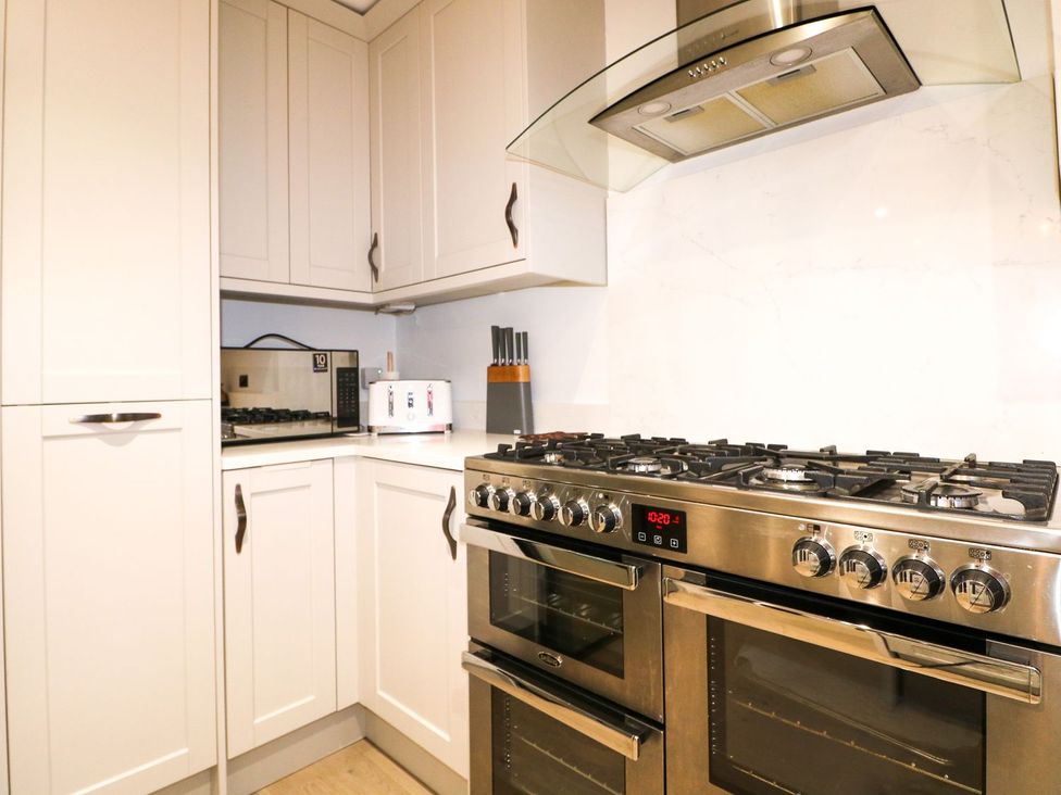 A kitchen with a gas stove and cabinets at Number 5