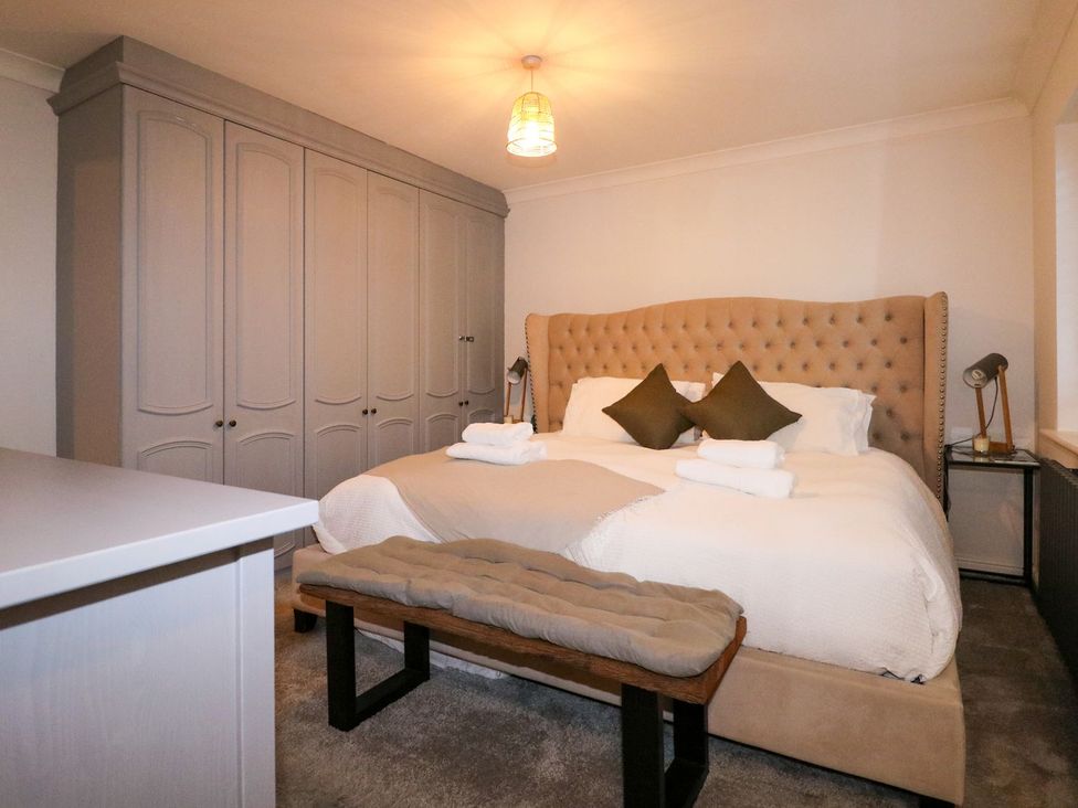 A bedroom with a bed, wardrobe, and bedside lamp at Number 5