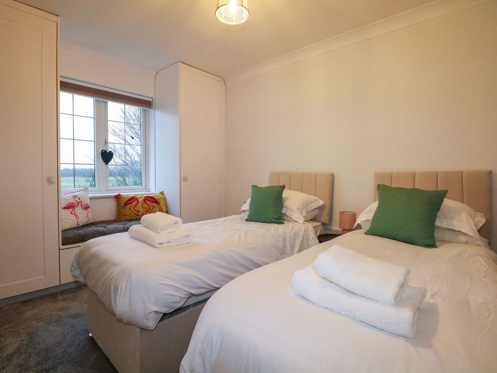 A bedroom with two beds and a window seat at Number 5 