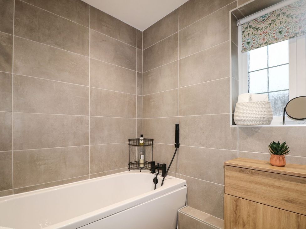 A bathroom with a bathtub and window at Number 5