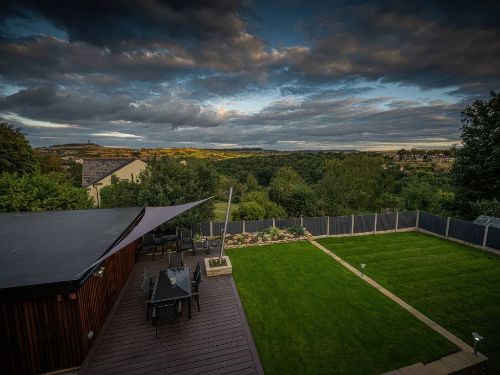 A garden with a table and chairs overlooking the landscape at The Luxury Shed in Huddersfield