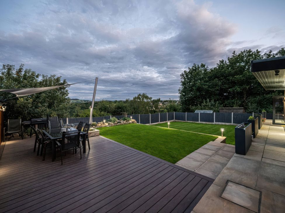 A garden with a table and chairs at The Luxury Shed in Huddersfield
