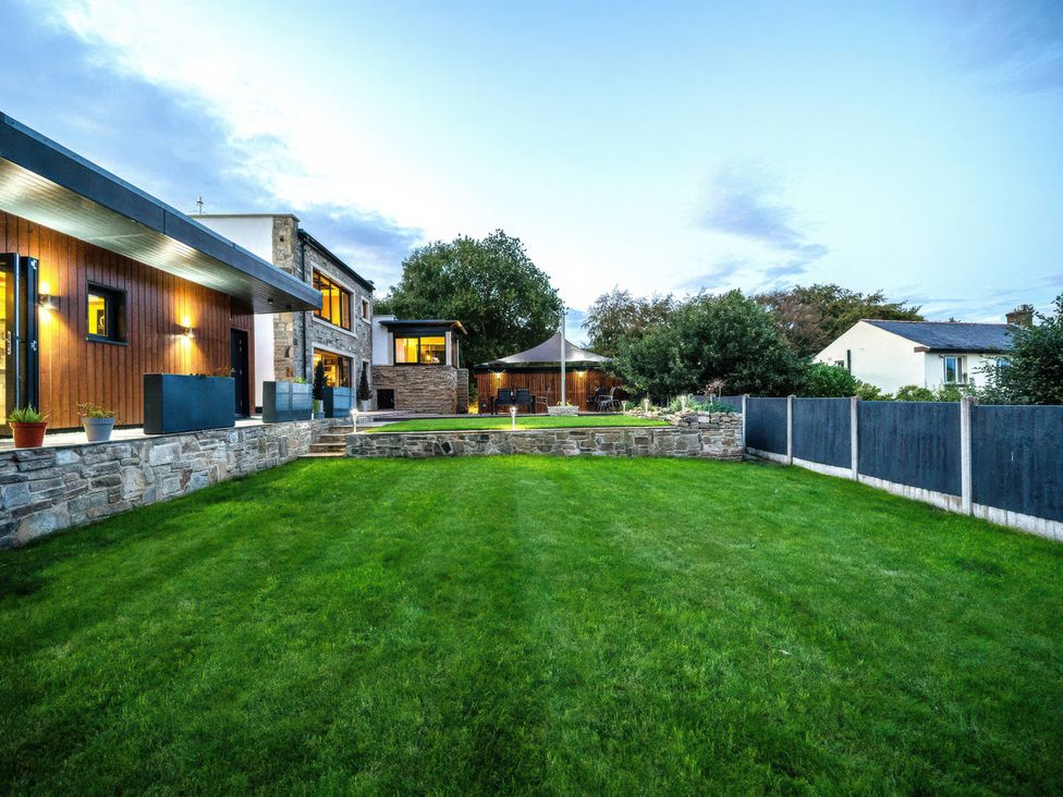 A garden with grass and patio furniture at The Luxury Shed in Huddersfield