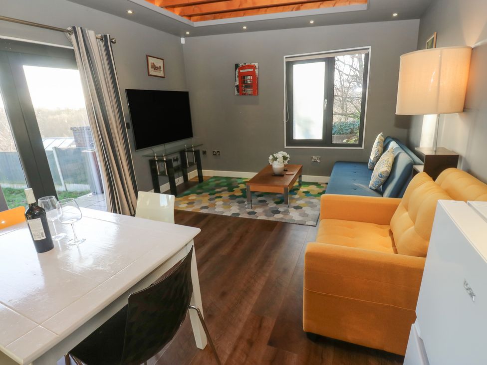 A living room with a television and sofa at The Luxury Shed in Huddersfield