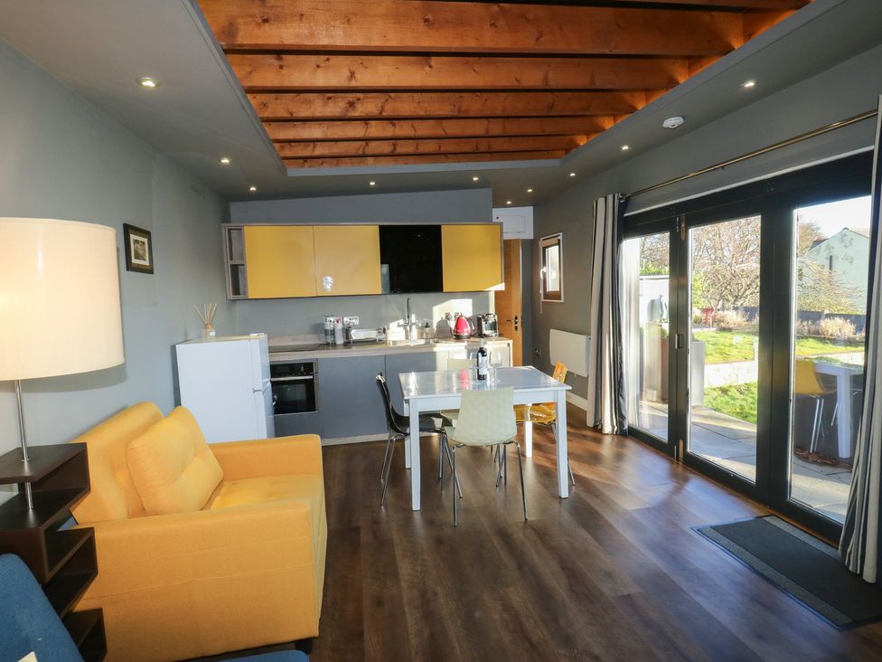 A living room with a kitchen area and a dining table at The Luxury Shed in Huddersfield