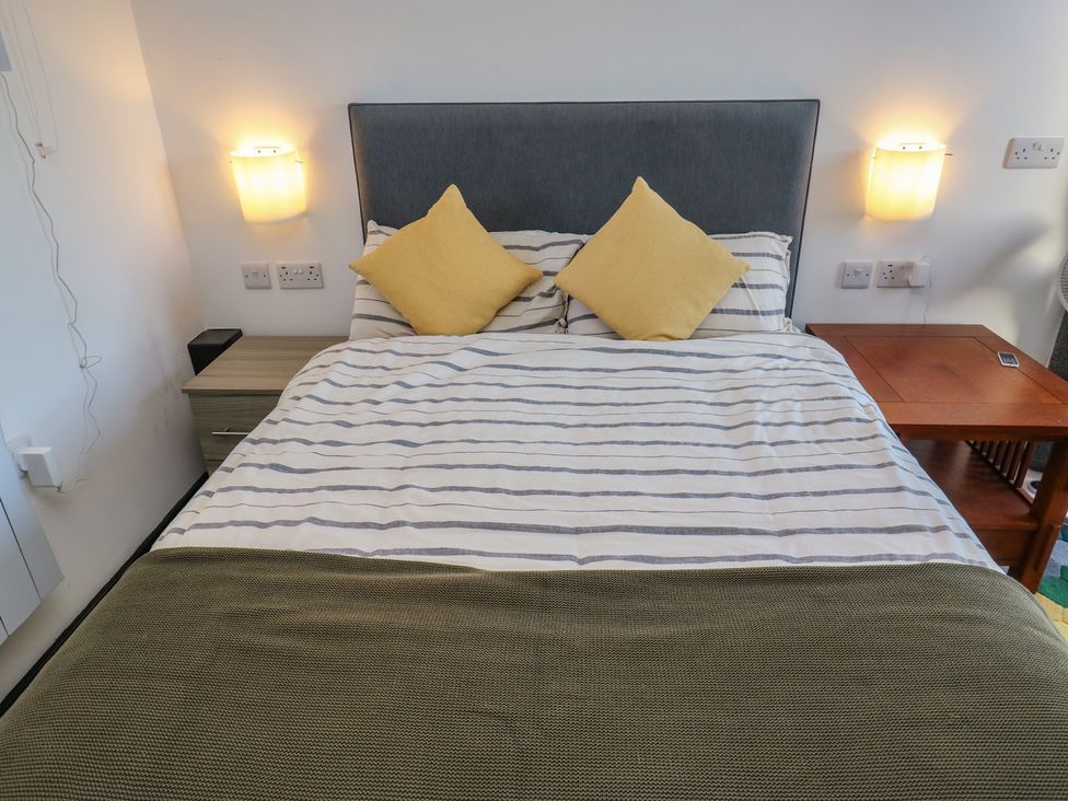 A bedroom with a bed and bedside table at The Luxury Shed in Huddersfield