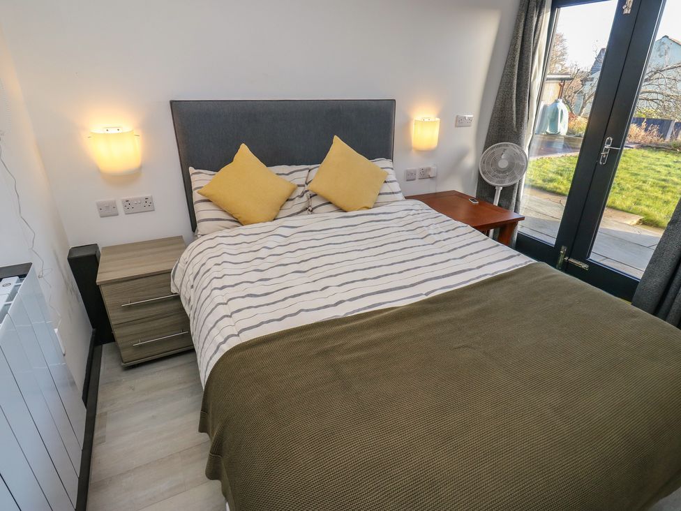 A bedroom with a bed and nightstand at The Luxury Shed in Huddersfield