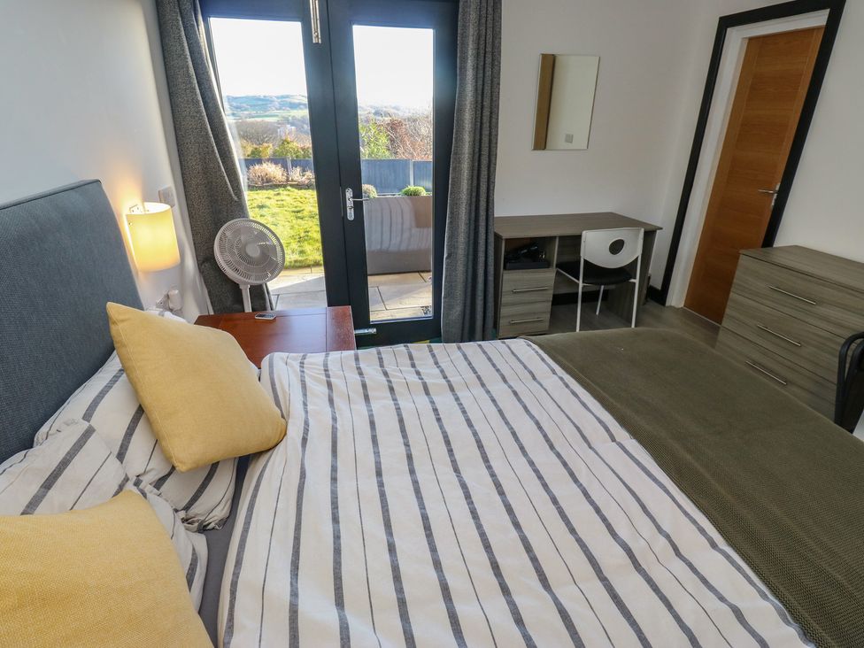 A bedroom with a bed and desk at The Luxury Shed in Huddersfield