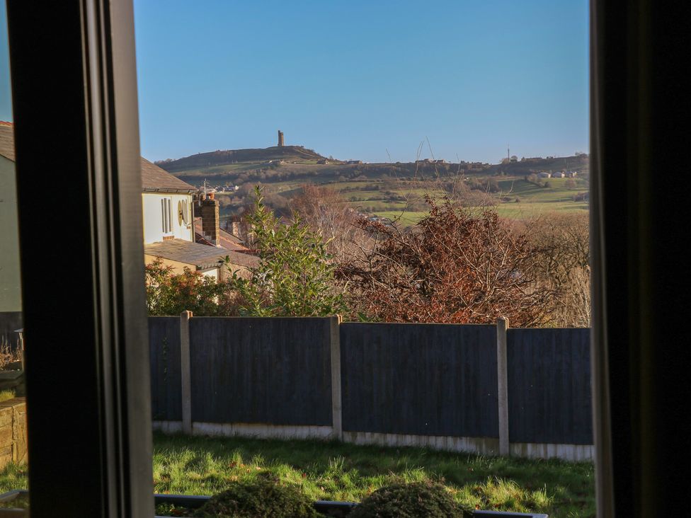 A view from a window showing hills and a fence at The Luxury Shed in Huddersfield