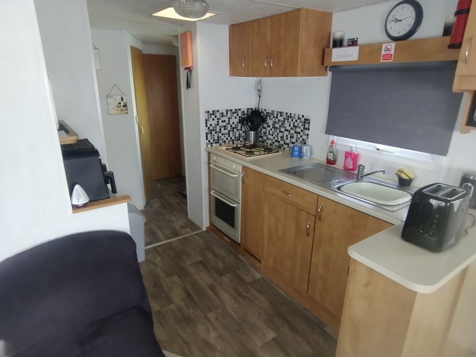 A kitchen with a stove and sink at Whispering Meadows - 104 Great Yarmouth