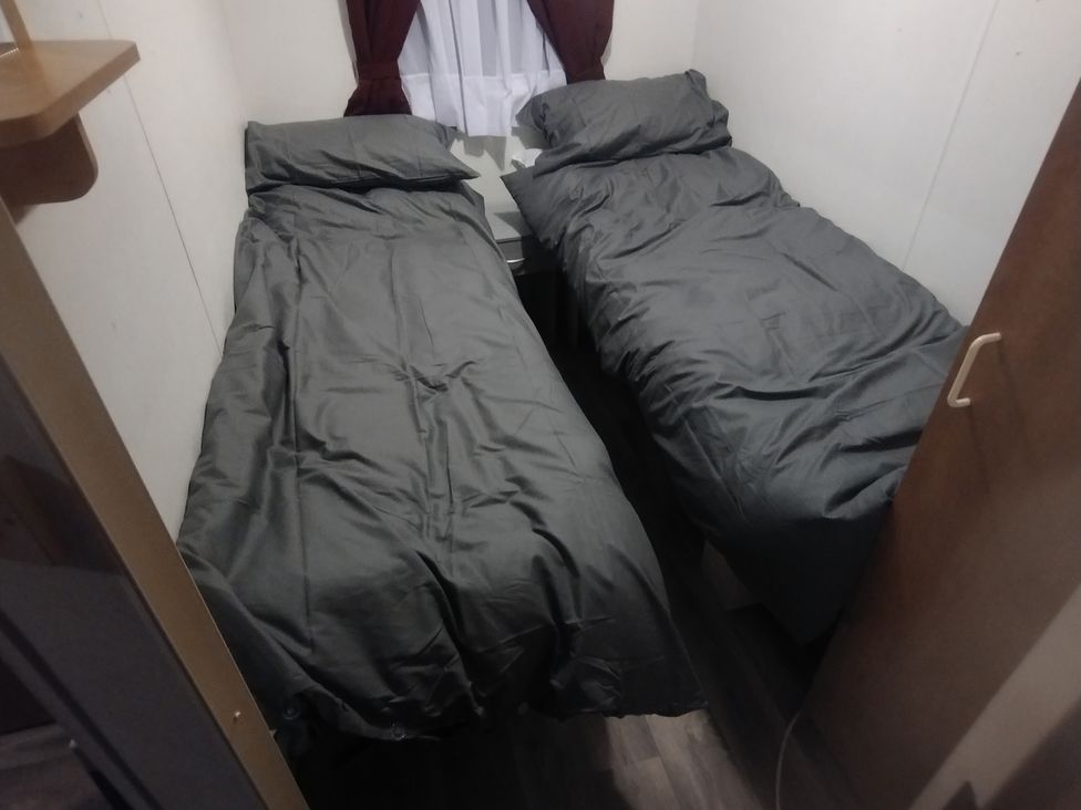 A bedroom with two beds and a window at Whispering Meadows - 104 Great Yarmouth