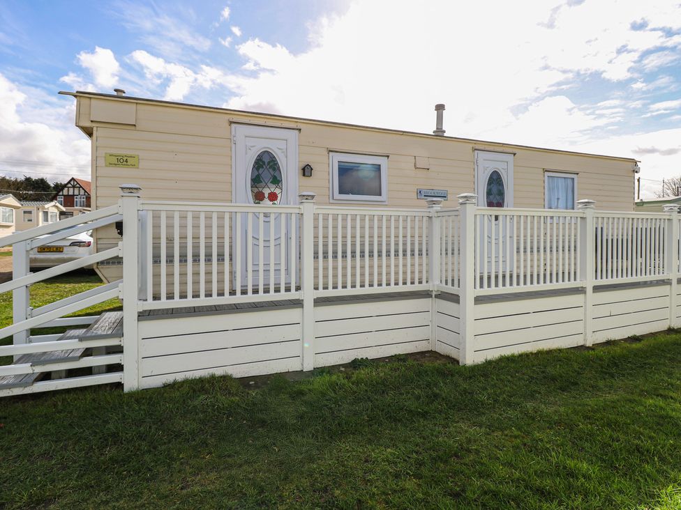 A mobile home with a porch and stairs at Whispering Meadows - 104 Hemsby