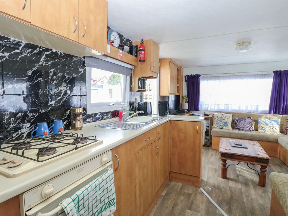 A kitchen with cabinets and a stove at Whispering Meadows - 104 Hemsby