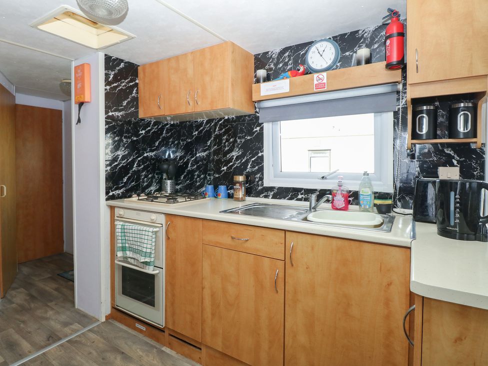 A kitchen with cabinets and appliances at Whispering Meadows - 104 Hemsby