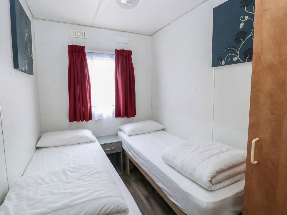 A bedroom with twin beds and a window at Whispering Meadows - 104, Hemsby