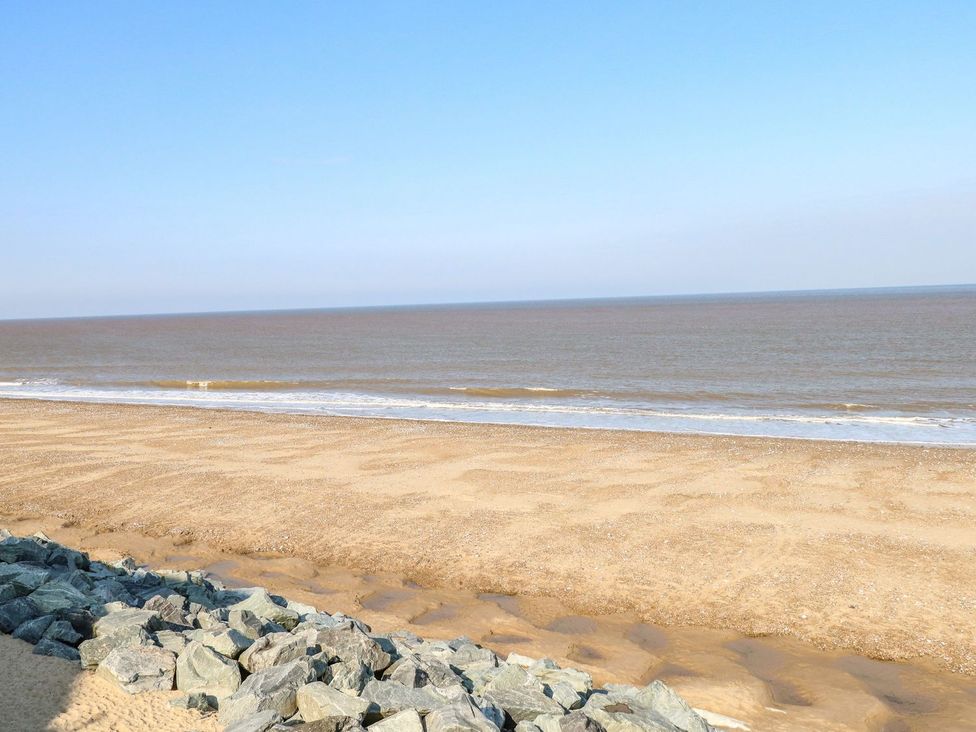 A beach with sand and waves at Whispering Meadows - 104, Hemsby