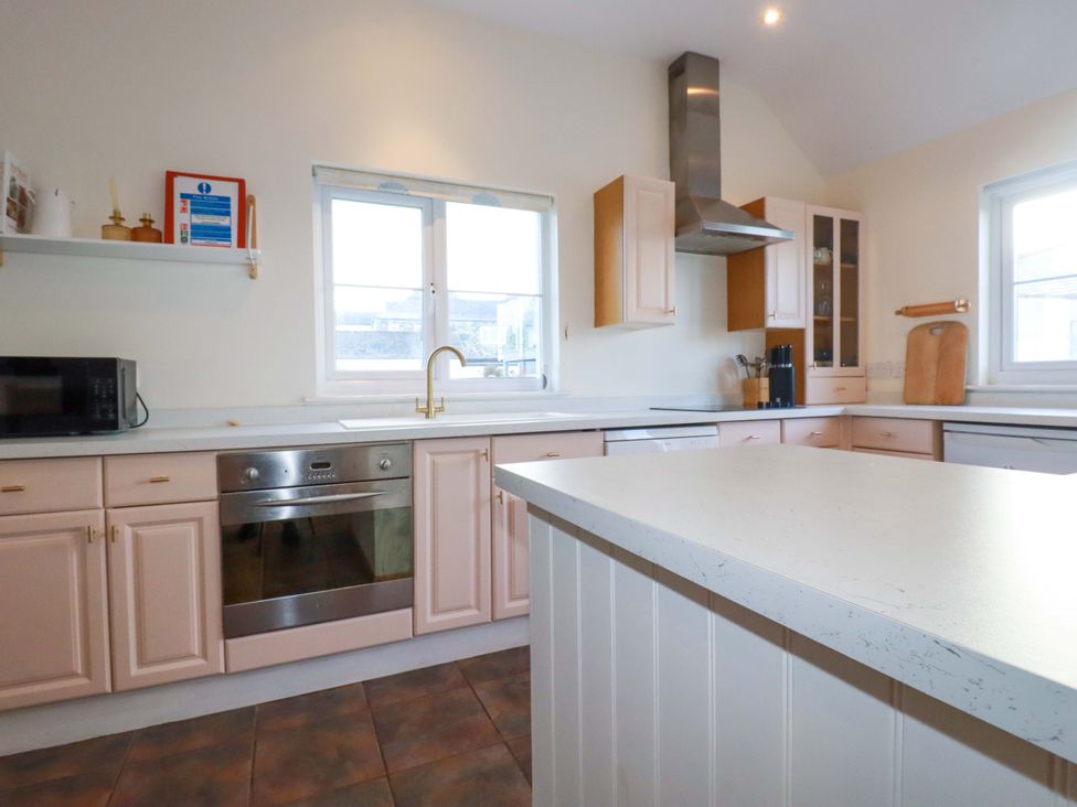 A kitchen with a sink and oven near a window at Cribba