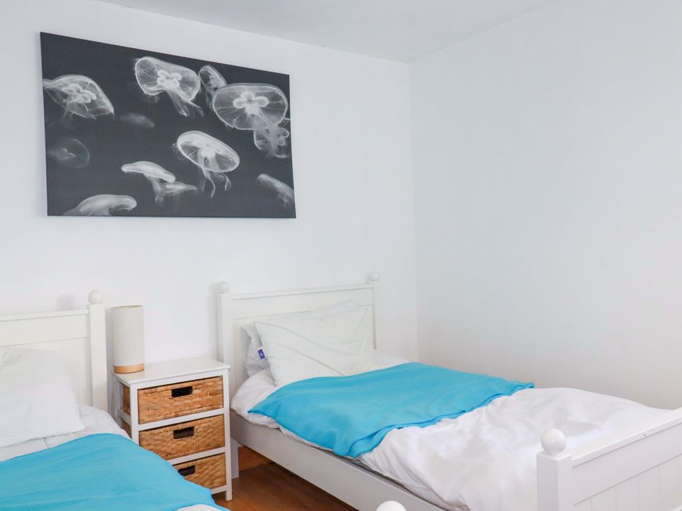 A bedroom with two beds and a nightstand at Cribba