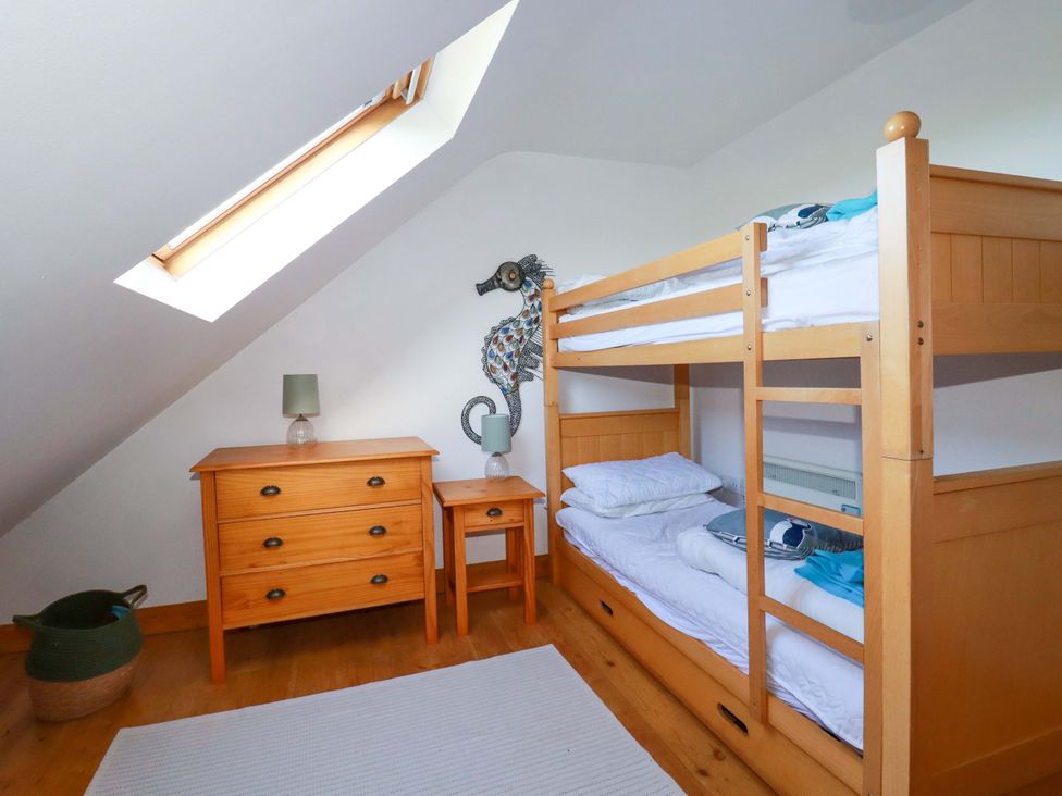 A bedroom with a bunk bed and wooden furniture at Cribba