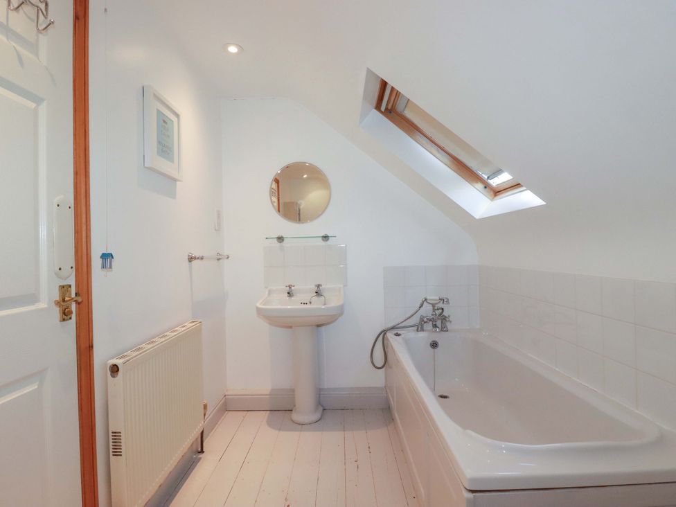 A bathroom with a bath and sink at Cribba 