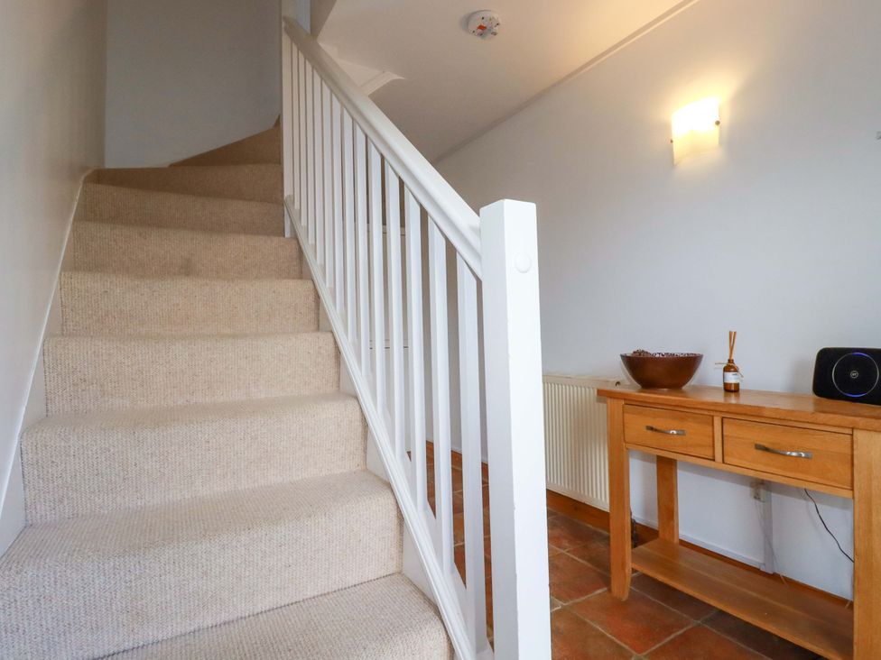 A staircase with a table and speaker in a hallway at Cribba