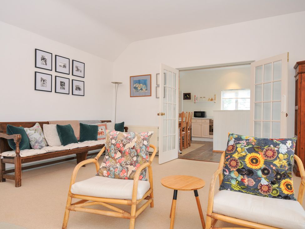 A living room with seating and doorway to kitchen at Cribba in Port Isaac