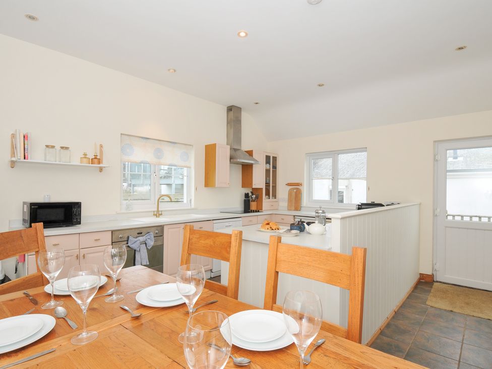 A kitchen with a table and chairs at Cribba in Port Isaac