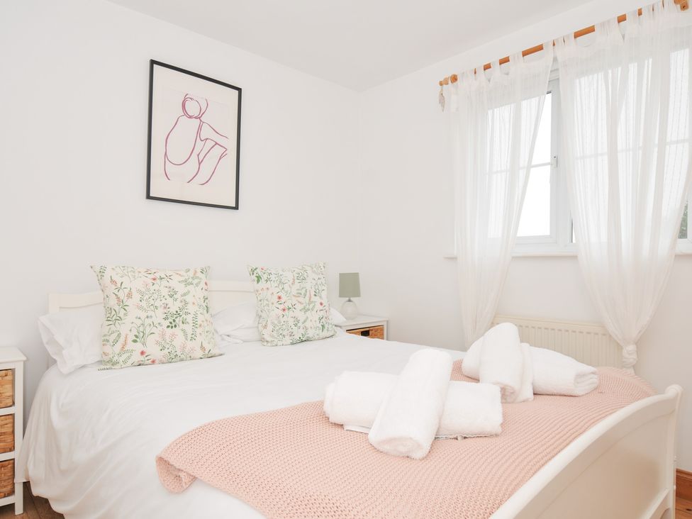 A bedroom with a bed, pillows, and a lamp at Cribba in Port Isaac