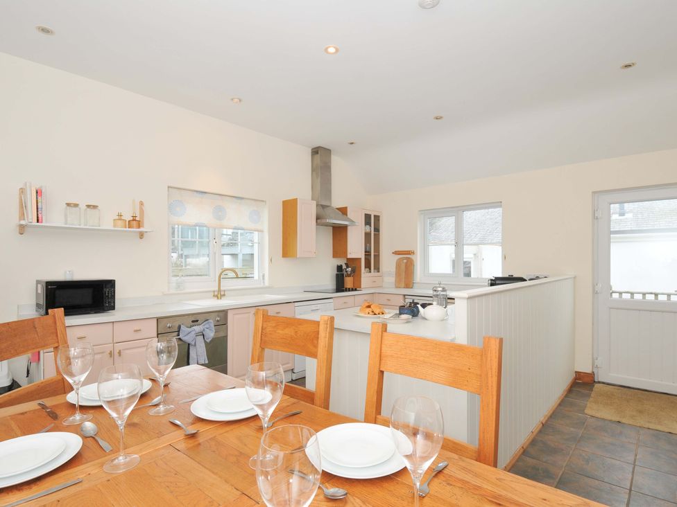 A kitchen with dining table and appliances at Cribba in Port Isaac