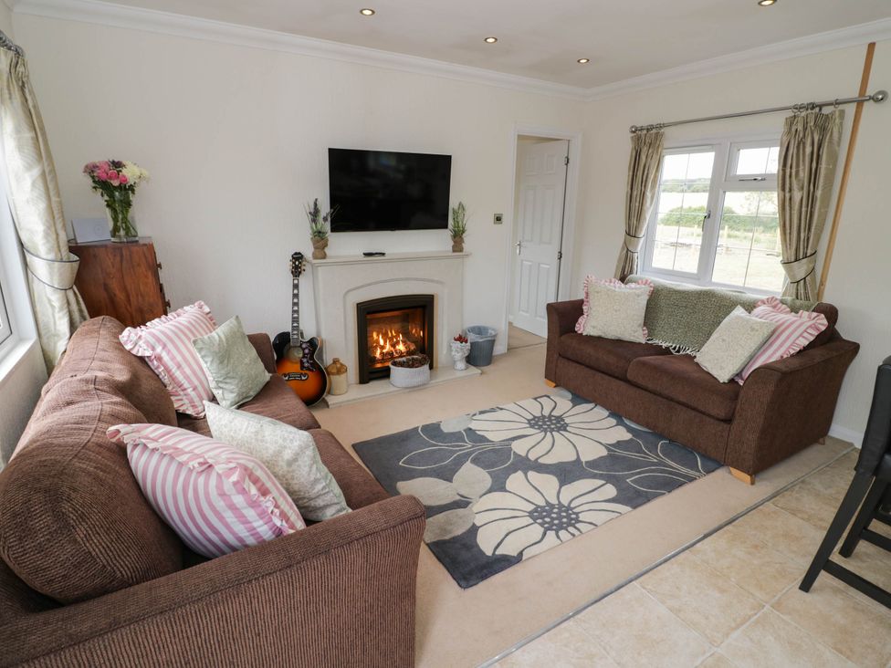 A living room with a sofa and fireplace at Cabin In The Woods in Silverstone