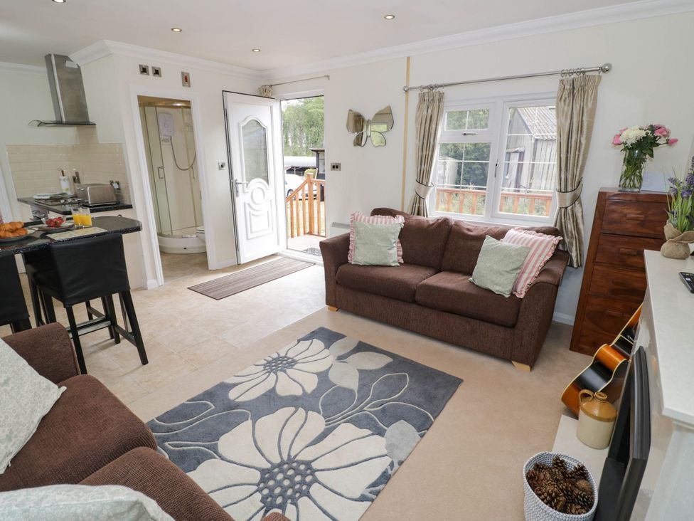 A living room with a sofa and table at Cabin In The Woods Silverstone