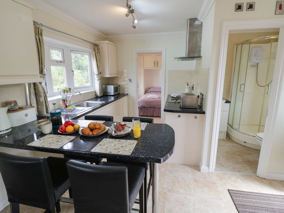 A kitchen with a table and chairs at Cabin In The Woods in Silverstone