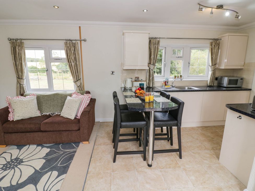 A kitchen with a sofa and dining area at Cabin In The Woods in Silverstone